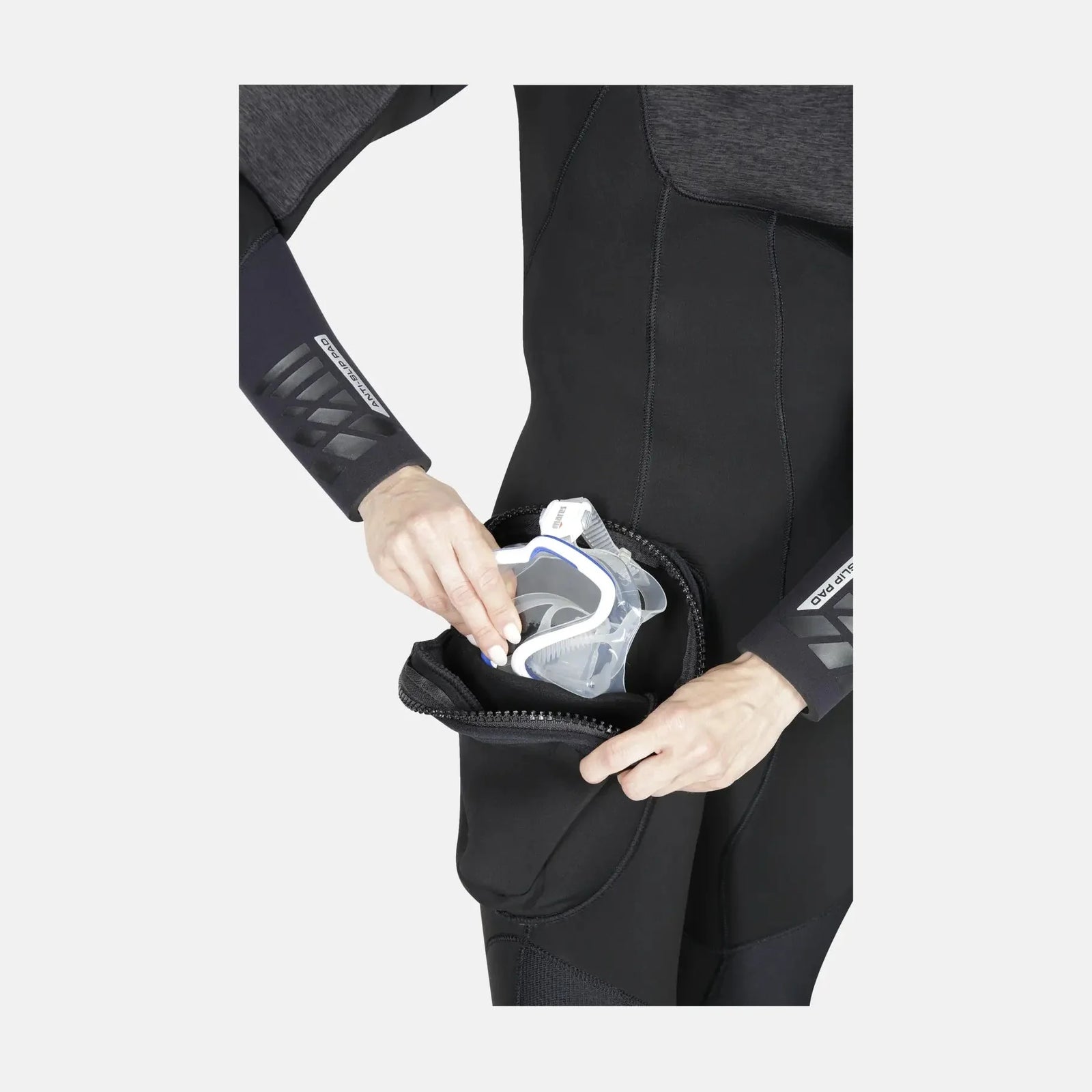 Person in a black wetsuit with a white object in a pocket on a light gray background